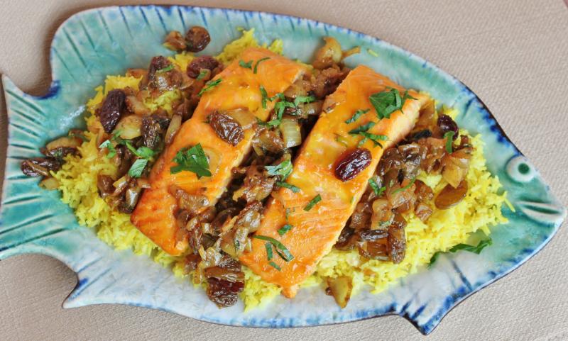 Yellow rice with fish and pomegranate raisin sauce 